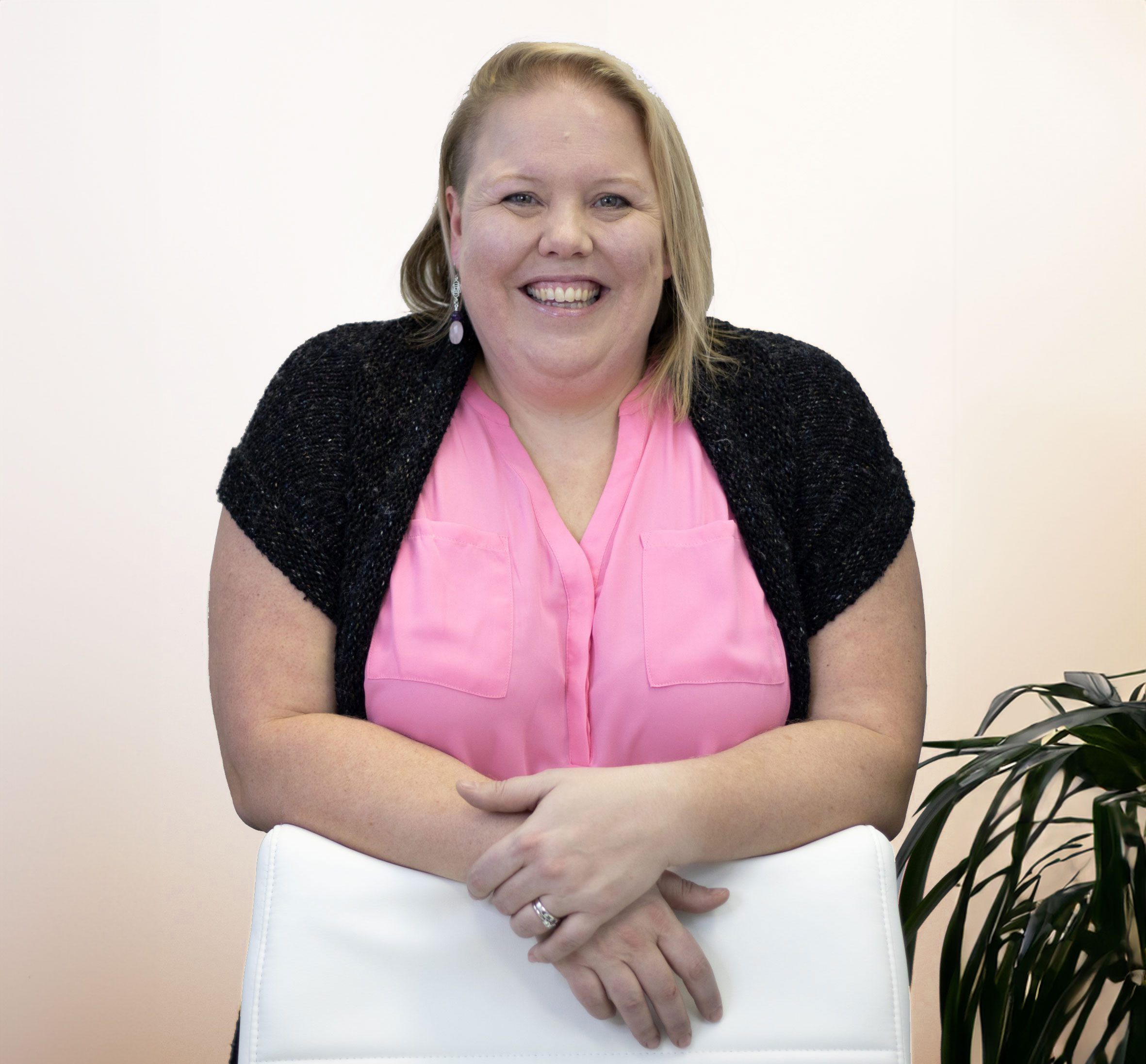 Dr. Katrina Cox Leaning on a Chair Smiling